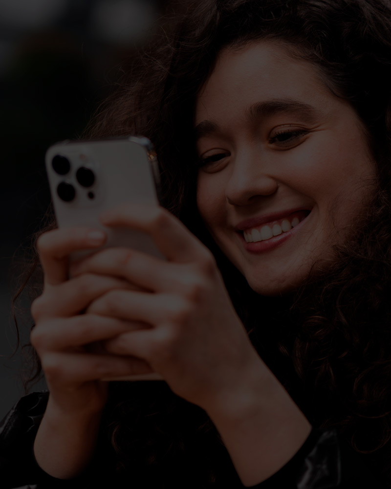 Mulher sorrindo ao usar o celular